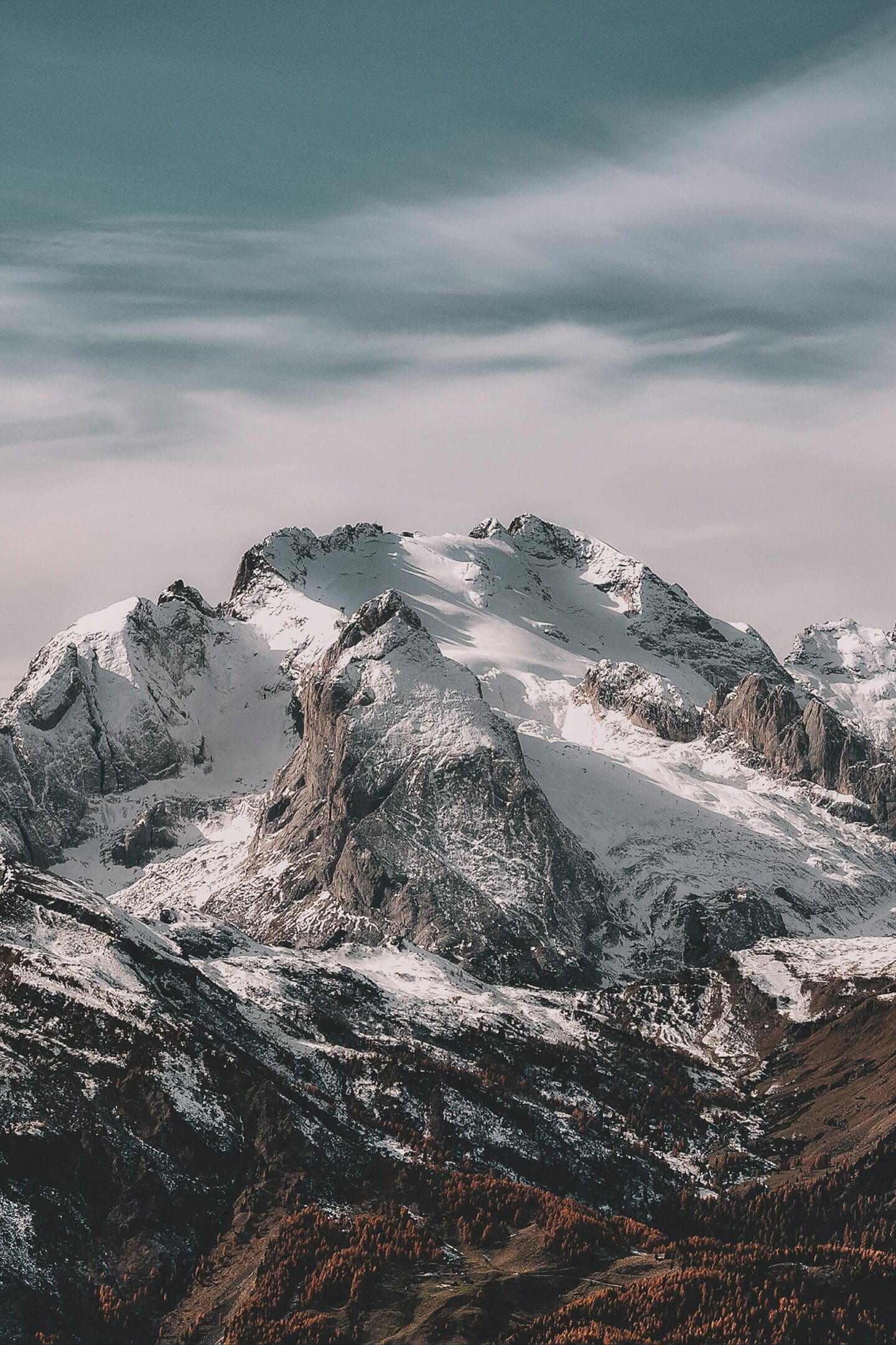 A mountain with snow on it and clouds in the sky.