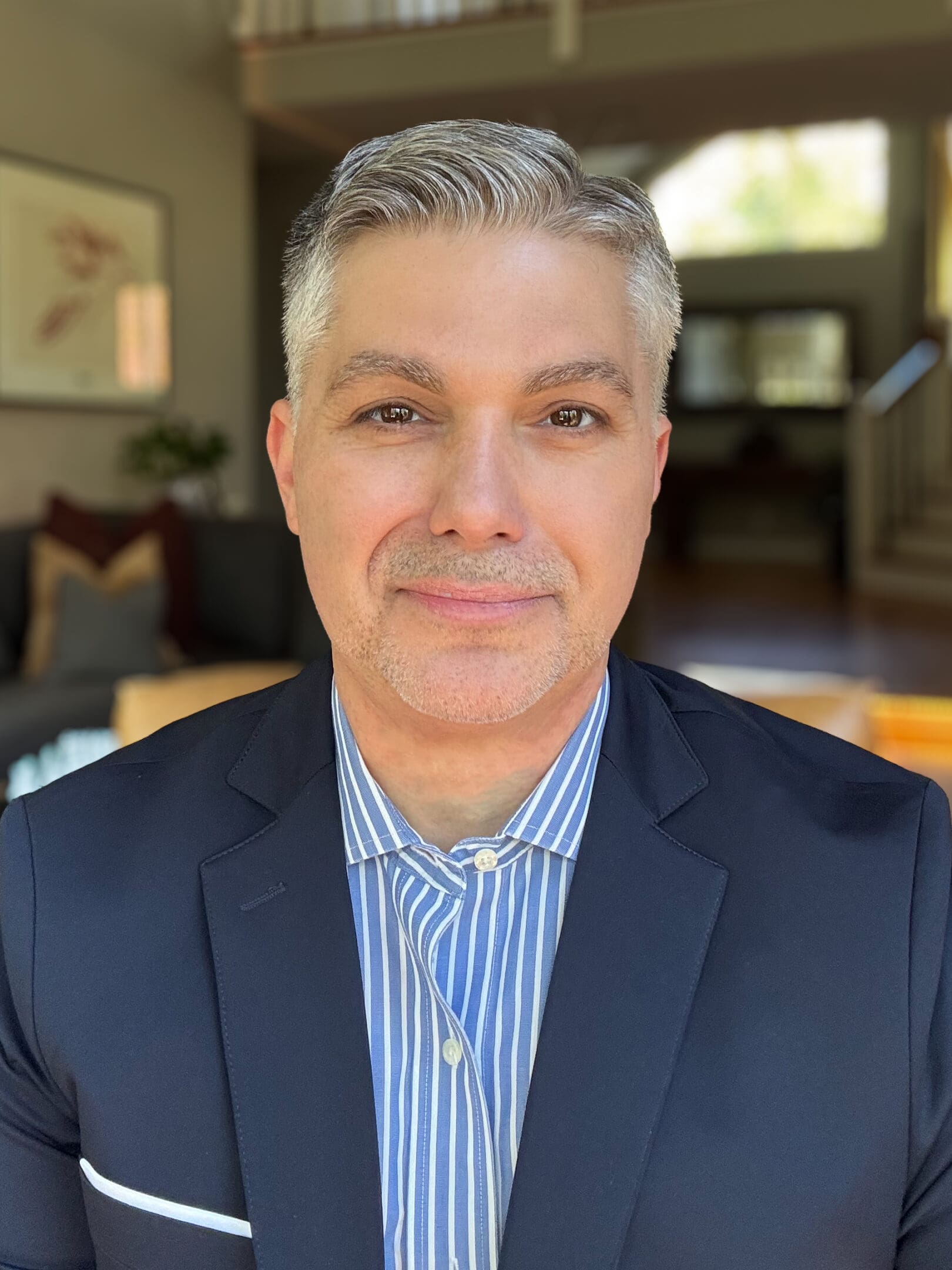 A man in a suit and tie smiling for the camera.